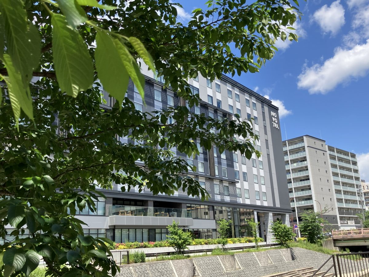 5月初旬の佐保川沿い。Novotelホテルと青空と新緑